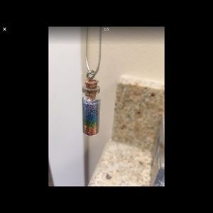 A very long silver rainbow necklace.